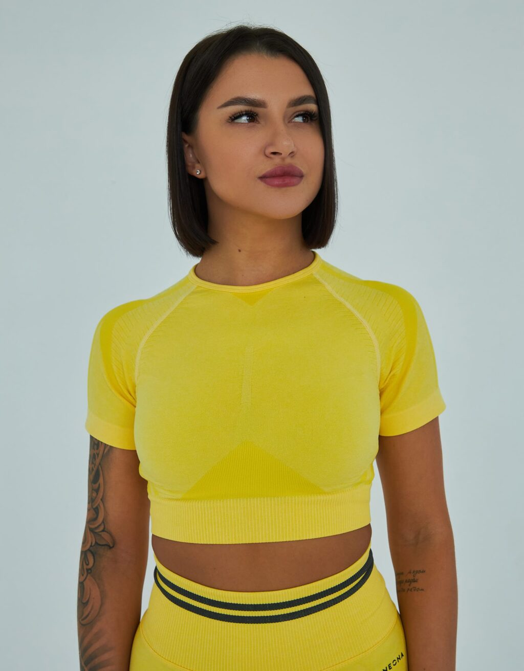 Жёлтая эластичная укороченная футболка, вид спереди.
